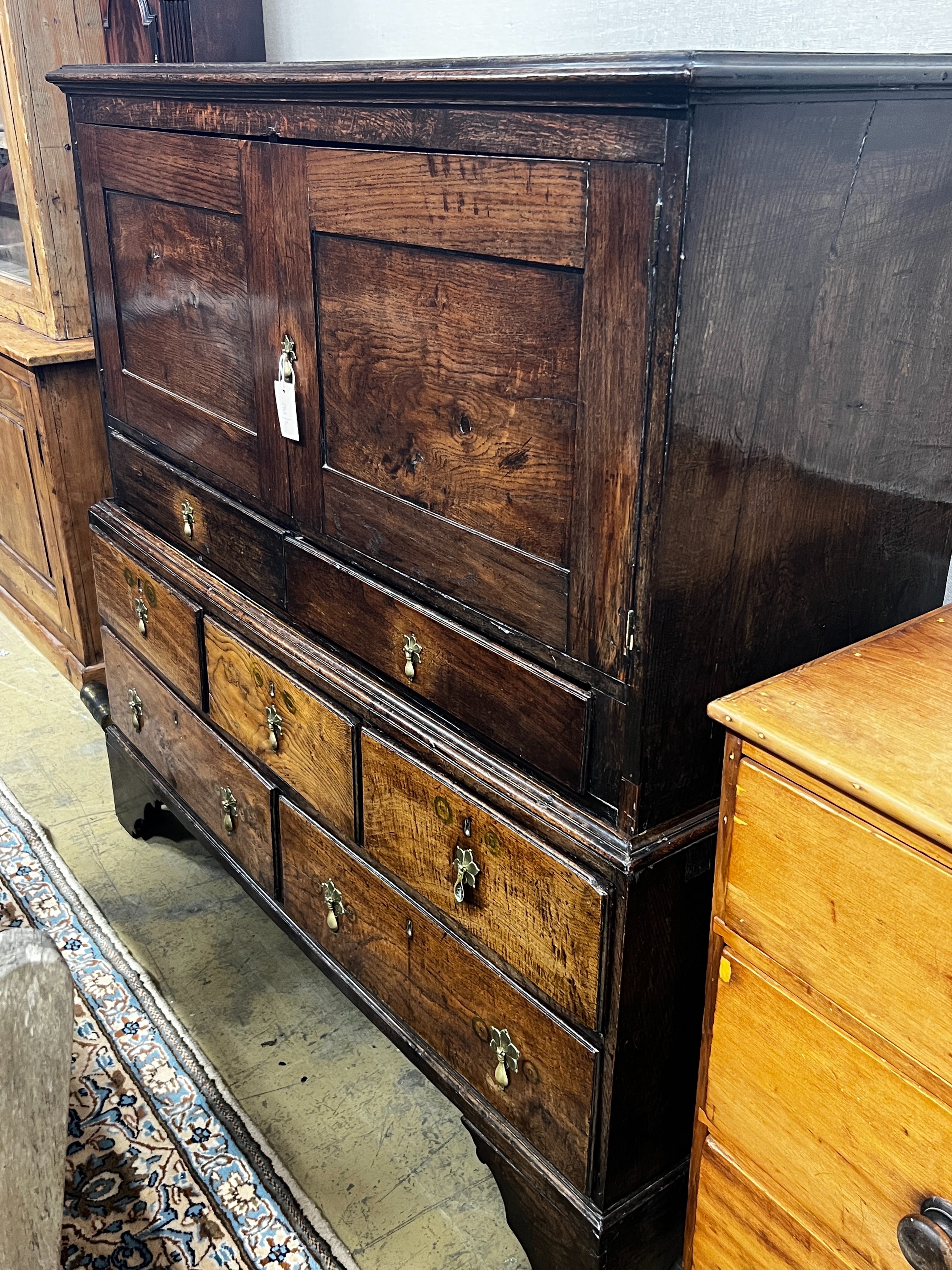 An 18th century oak low press cupboard, length 136cm, depth 53cm, height 137cm